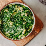 Keto creamed spinach in a bowl on a wooden board